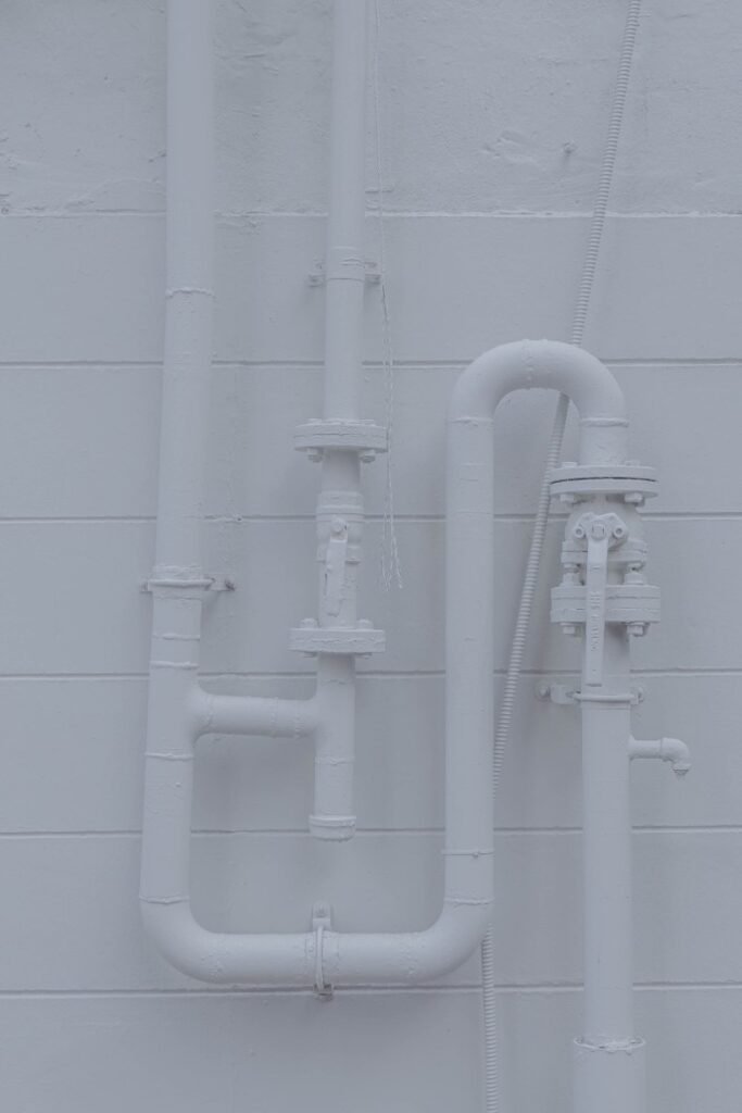 White painted plumbing setup with cleanout valves